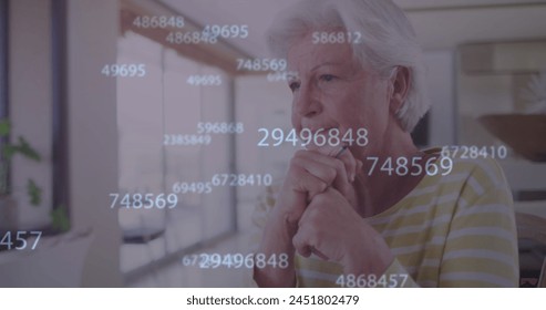 Image of numbers processing over thoughtful caucasian senior woman leaning on at home. retirement lifestyle and data processing technology concept digitally generated image.