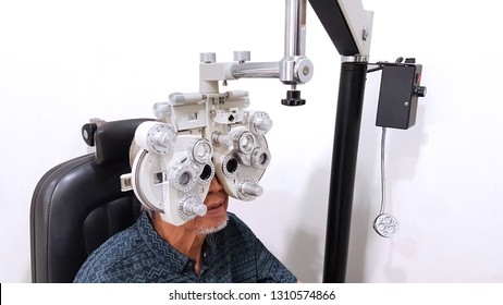 Image Of Old Man Doing Eyes Test By Using Phoropter In The Hospital