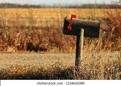 An image of a an old rural mailbox on a wooden post. 