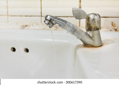 image of old sink with damaged water tap .