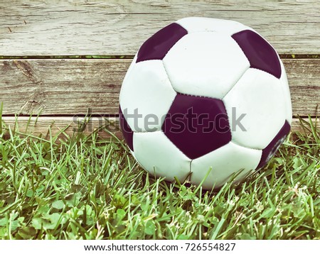image of old soccer ball on green grass.