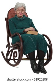 Image Of An Old Woman Sitting On A Rocker With A Closed Book In Her Lap.