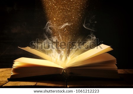 image of open antique book over wooden table