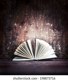 Image of opened magic book with magic lights/ 