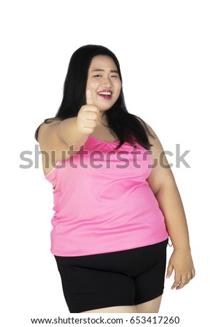 Image of overweight woman showing a thumb up while smiling at the camera, isolated on white background