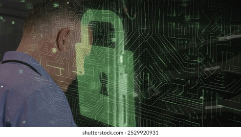 Image of padlock symbol, over motherboard, man using laptop in server room and data processing. online security, cyber crime and digital interface concept digitally generated image.