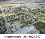 The image is a panoramic view of a residential area with a mix of houses and a large building. The houses are spread out across the area, with some closer to the center and others further away