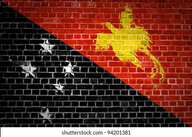 An image of the Papua New Guinea flag painted on a brick wall in an urban location