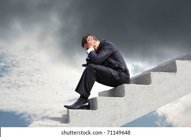 Image of pensive businessman sitting on stairs against thunderclouds - Powered by Shutterstock