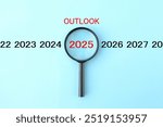 Image photo of magnifying glass examining outlook for 2025