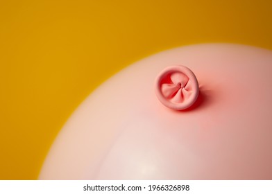 An image of a pink balloon on a yellow background. Metaphor prevention of hemorrhoids, anus hygiene, proctology, bowel health. Selective focus
