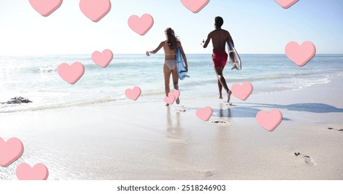 Image of pink hearts over diverse couple running with surfboards on beach. Summer, vacation, lifestyle and digital interface concept digitally generated image. - Powered by Shutterstock