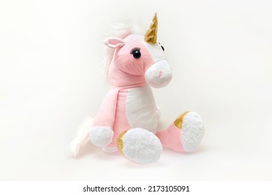 Image of a pink soft unicorn toy sitting at white background. Isolated studio image - Shutterstock ID 2173105091