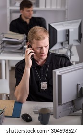 Image Of Policeman Talking On Phone With Crime Witness