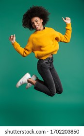 Image Of A Positive Cheery African Curly Woman Posing Isolated Over Dark Blue Wall Background Jumping.