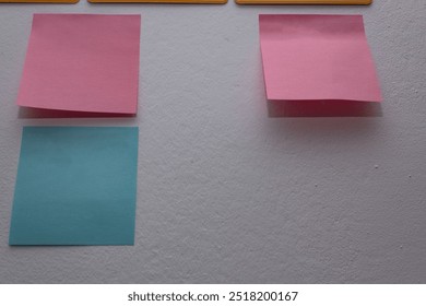 Image of post-its stuck to the wall without writing. They are blank. 
They have different colors, shapes and locations within the photograph.