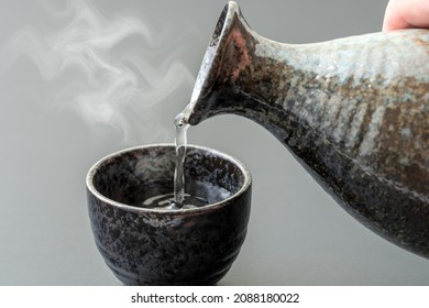 An image of pouring Japanese "liquor" into a bowl. - Shutterstock ID 2088180022