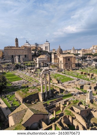 The image presents a stunning panoramic view of the Roman Forum, with ancient ruins, columns, and historical buildings. Visitors are scattered across the area, and in the background, more iconic Roman