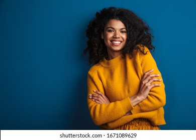 Image of a pretty cheerful optimistic young african woman posing isolated over blue wall background. - Shutterstock ID 1671089629