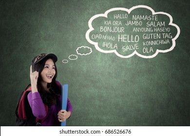 Image of pretty high school student learning multilingual while looking a cloud on the chalkboard - Powered by Shutterstock