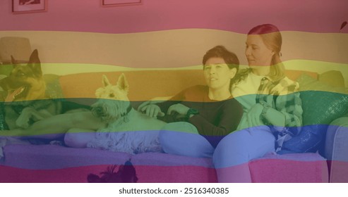 Image of pride rainbow flag over happy caucasian lesbian couple relaxing on couch with pet dogs. Domestic life, love, lgbtq, gay, lesbian, pride and lifestyle, digitally generated image. - Powered by Shutterstock