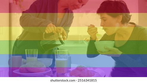 Image of pride rainbow stripes over happy caucasian lesbian couple having coffee and breakfast. Domestic life, communication, lgbtq, gay, lesbian, pride and lifestyle, digitally generated image. - Powered by Shutterstock