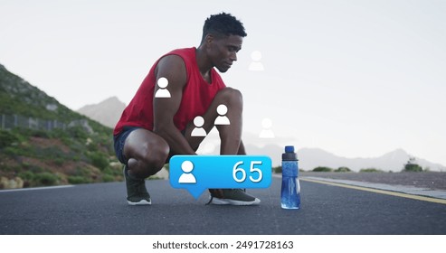 Image of profile icon with increasing number over african american man tying shoelace on street. Digital composite, athlete, exercise, fitness, bottle, social media, notification, technology, sky. - Powered by Shutterstock