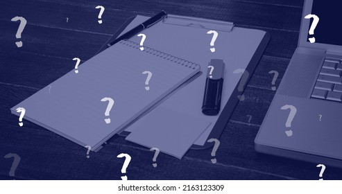 Image of question marks floating over notepads and laptop on office desk. data, working in office and technology concept digitally generated image.