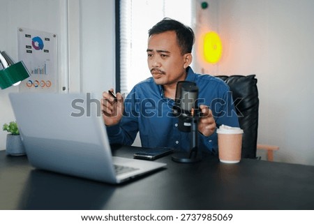 Image of radio host using microphone and laptop to recording podcast in home studio. Radio, podcasts and technology concept 
