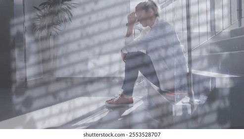 Image of rain on window over unhappy caucasian female doctor sitting on stairs in hospital. Sadness, work, stress, depression, healthcare services and mental health, digitally generated image. - Powered by Shutterstock