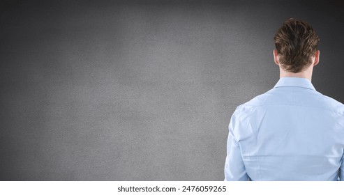 Image of rear view of caucasian man touching invisible screen on grey background with copy space. Business technology concept - Powered by Shutterstock