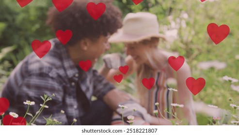 Image of red hearts over happy diverse couple gardening and laughing in sunny garden. Couple, gardening, nature, summer, togetherness, love and romance, digitally generated image. - Powered by Shutterstock