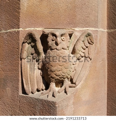 An image of a red sandstone owl stone carving