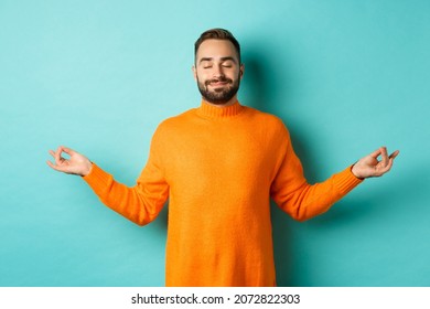 Image Of Relaxed And Relieved Man Close Eyes And Smiling, Feeling Stress-free, Meditating With Calm Expression, Standing Over Light Blue Background