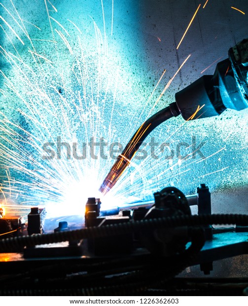 Image of robotic machine welding metal\
fasteners, Manufacturing.