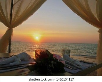 image of romantic dinner on the beach during sunset 