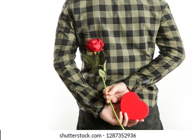 Image Of The Romantic Guy Holding A Red Rose And Heart-shaped Box Behind His Back