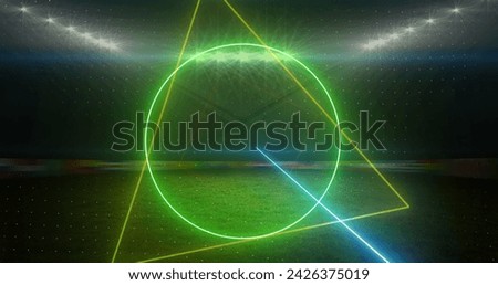 Image of rotating neon shapes and lights over floodlit sports field. sport, competition and communication technology concept, digitally generated image.
