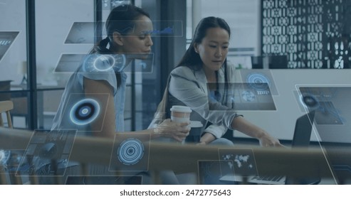 Image of round scanners and data processing over diverse businesswomen discussing at office. Computer interface and business technology concept