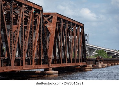 Image of a rust colored rail road bridge and bright blue sky taken from the river. - Powered by Shutterstock