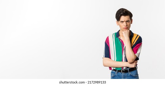 Image Of Sad Gay Man Looking At Camera, Sulking Displeased And Upset, Leaning On Hand, Standing Over White Background