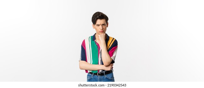 Image Of Sad Gay Man Looking At Camera, Sulking Displeased And Upset, Leaning On Hand, Standing Over White Background