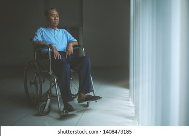Image Of A Sad Old Man Sitting In A Wheelchair While Looking Out The Window