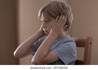 Image Of Sad Small Boy Plugging Ears With Hands