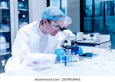 Image of scientist looking in microscope while working on medical research in science laboratory