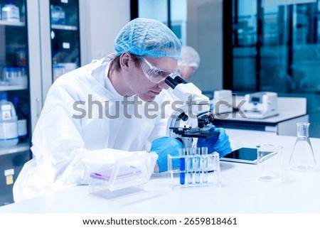 Image of scientist looking in microscope while working on medical research in science laboratory