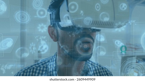 Image of scopes scanning on screens over man wearing vr headset. global data processing, communication and global technology concept digitally generated image.