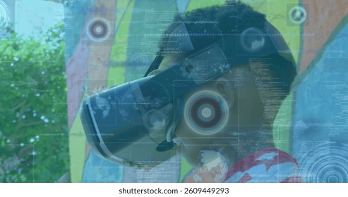 Image of scopes scanning over boy wearing vr headset. global data processing, communication and global technology concept digitally generated image.