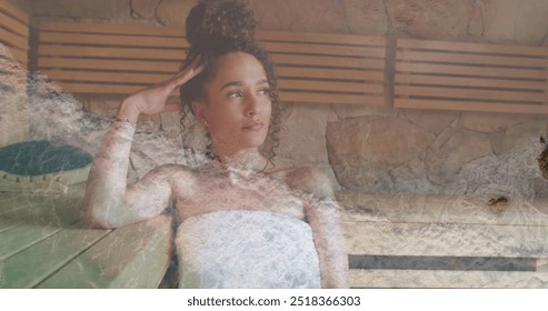 Image of sea lapping on beach over happy biracial woman relaxing in sauna. Nature, self care, beauty, relaxation, wellbeing and lifestyle, digitally generated image. - Powered by Shutterstock