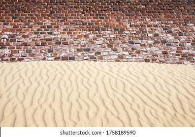 Image of seawall made of bricks in Bray-Dunes, France. Vertical waves on the sand. Interesting pattern of man made and natural design.